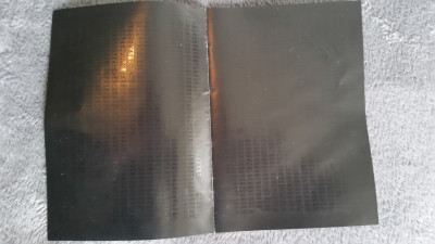 Nei, jeg har ikke puttet manualen i ovnen. Dette er kodeboken, spillets kopibeskyttelse. For å spille må du slå opp koder i boken, og den er laget så mørk for å være vanskelig å kopiere.