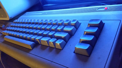 En Commodore 64 i sitt rette element, opplyst av en knøttliten CRT-skjerm.